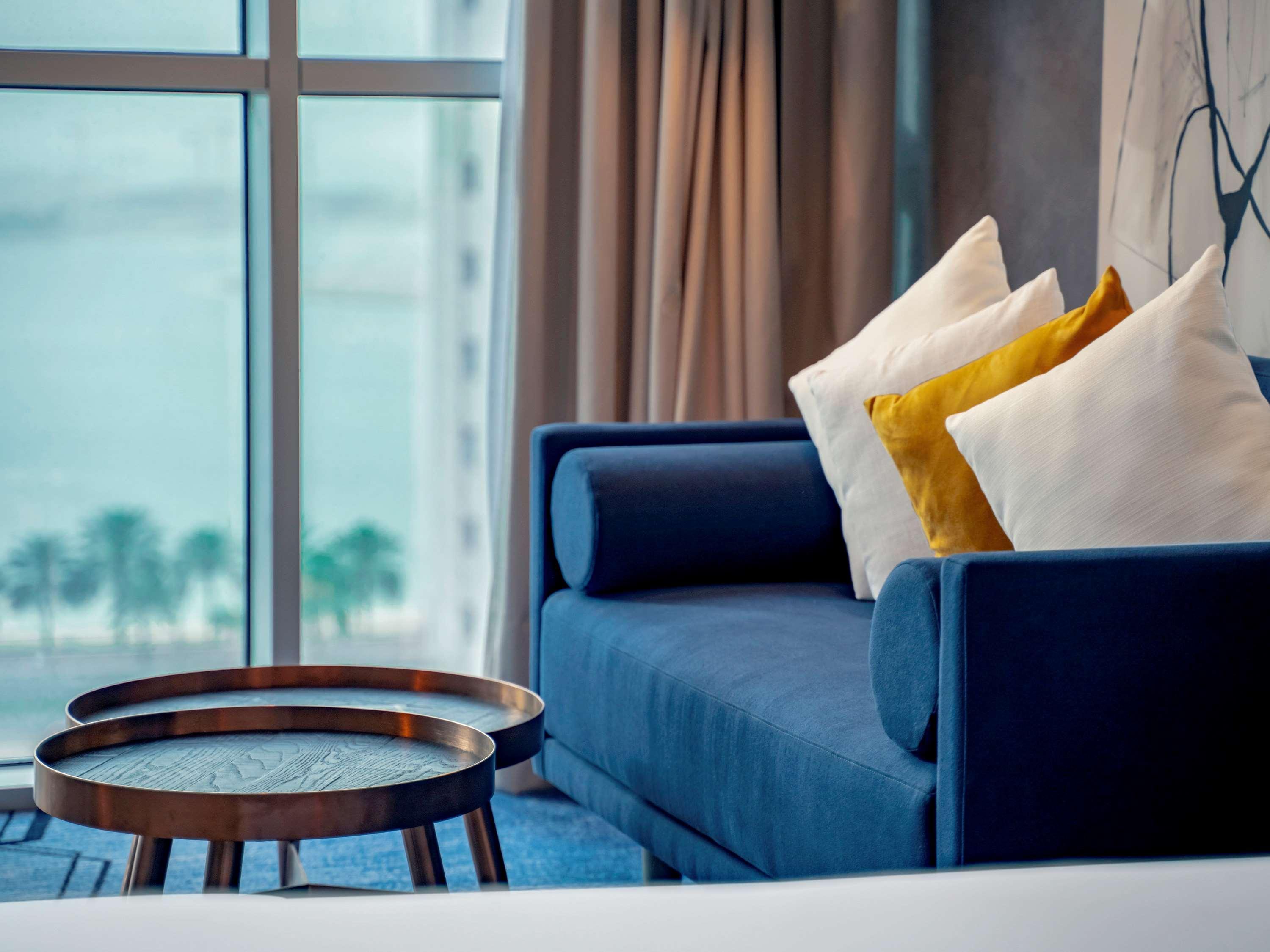 Pullman Sharjah Hotel Exterior foto A sofa in a hotel room