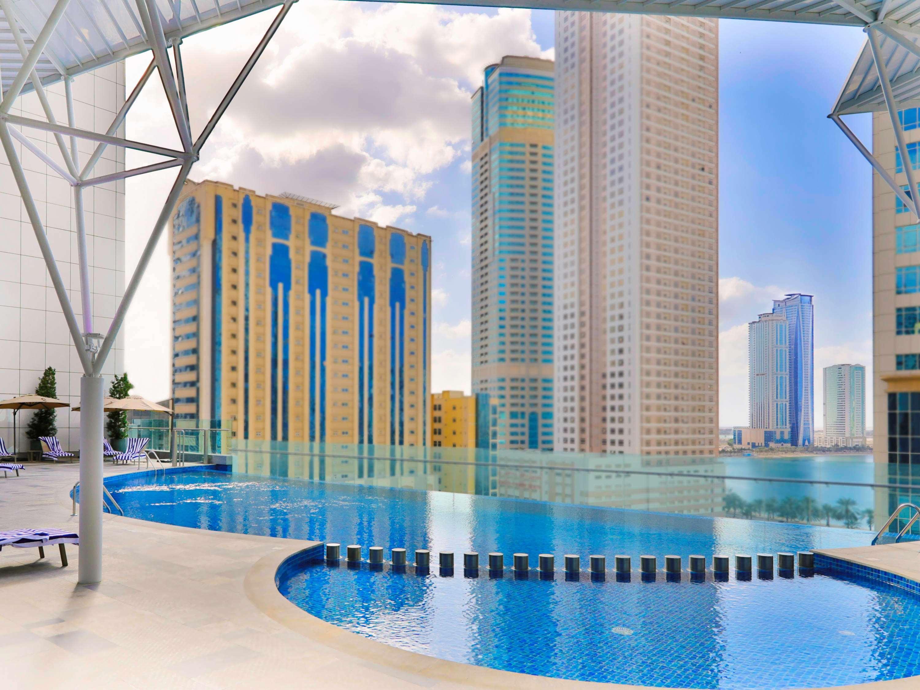 Pullman Sharjah Hotel Exterior foto The swimming pool at the complex